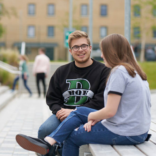 Students sat on bench at Pittville Student Village