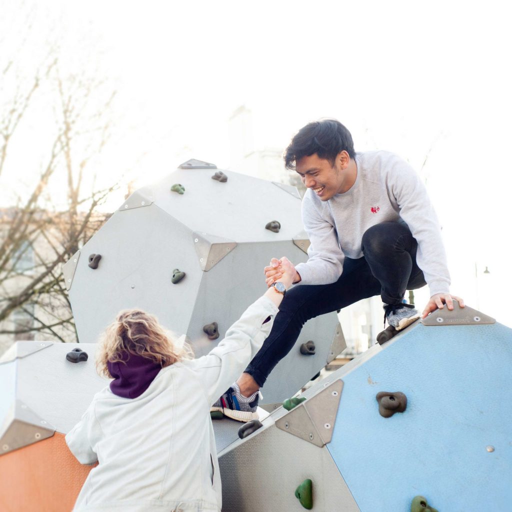 Students climbing up play equipment