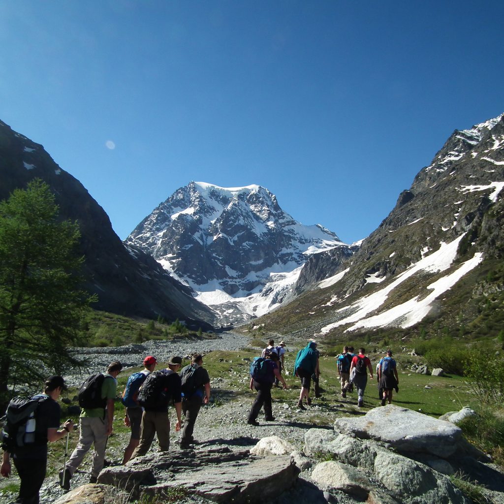 Students on Geography course walking in mountains in Swiss Alps whilst on field trip