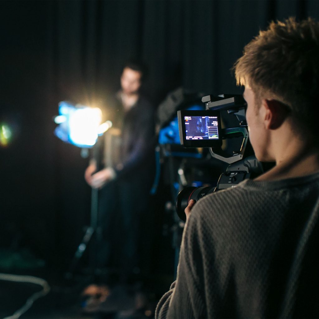 Students on Film and Television Production (Level 6) course looking through camera during practical in studio at Park campus