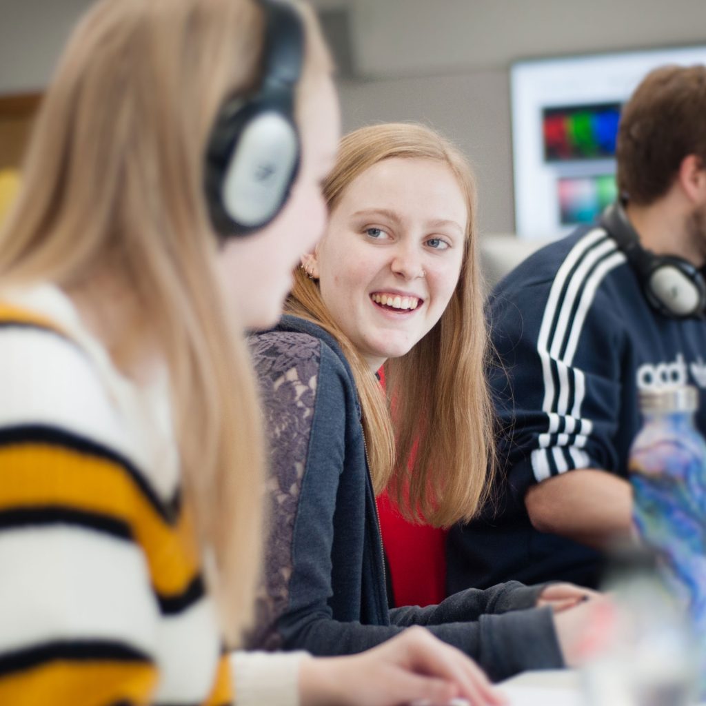 Girl sat at computer smiling