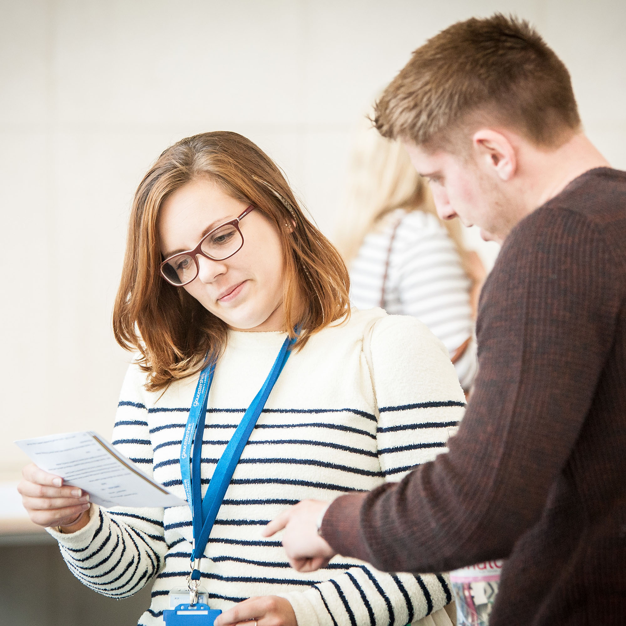 A man pointing out something on a typed piece of paper to a woman