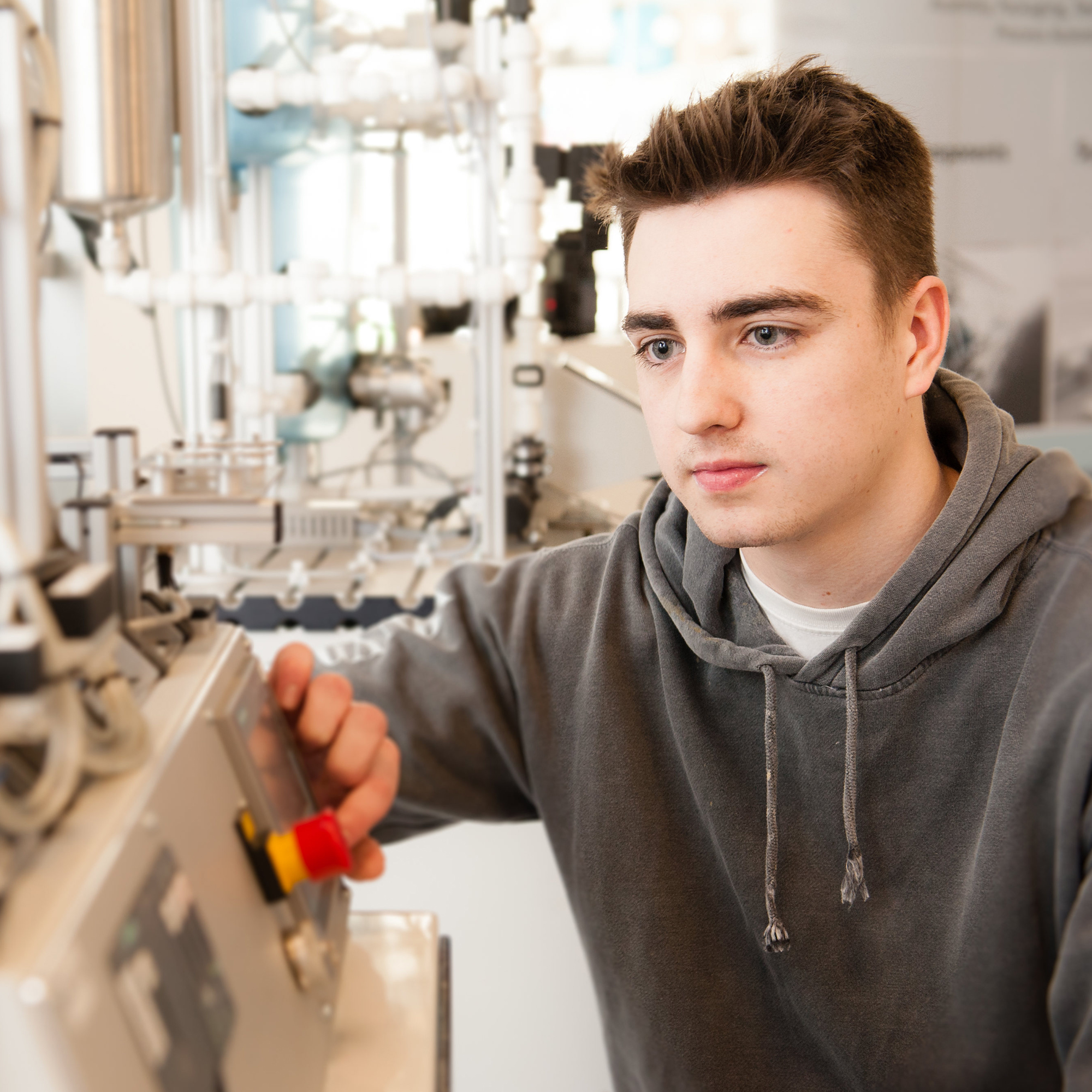 A student preparing to press a button on some engineering equipment