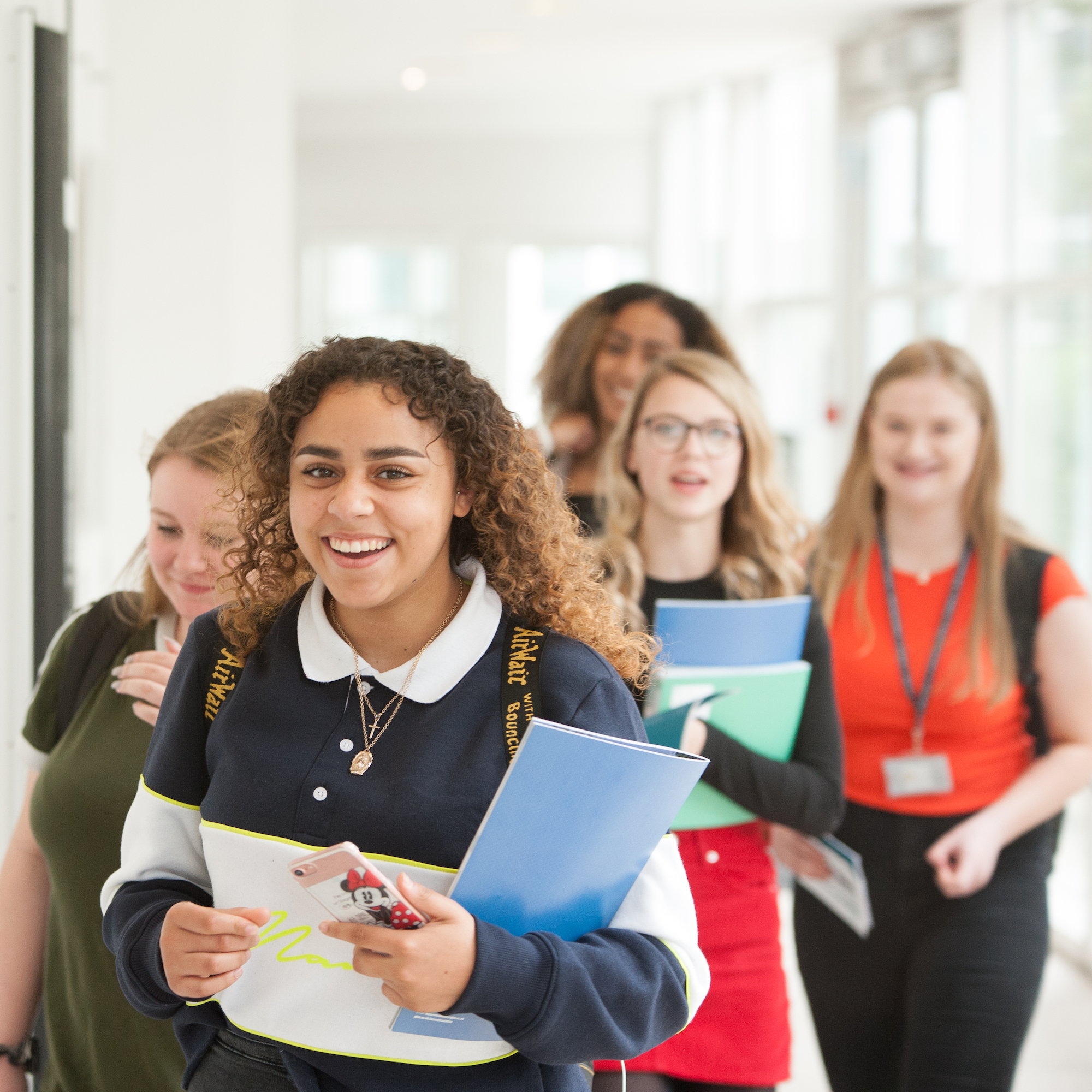 Students smile walking down a corridor