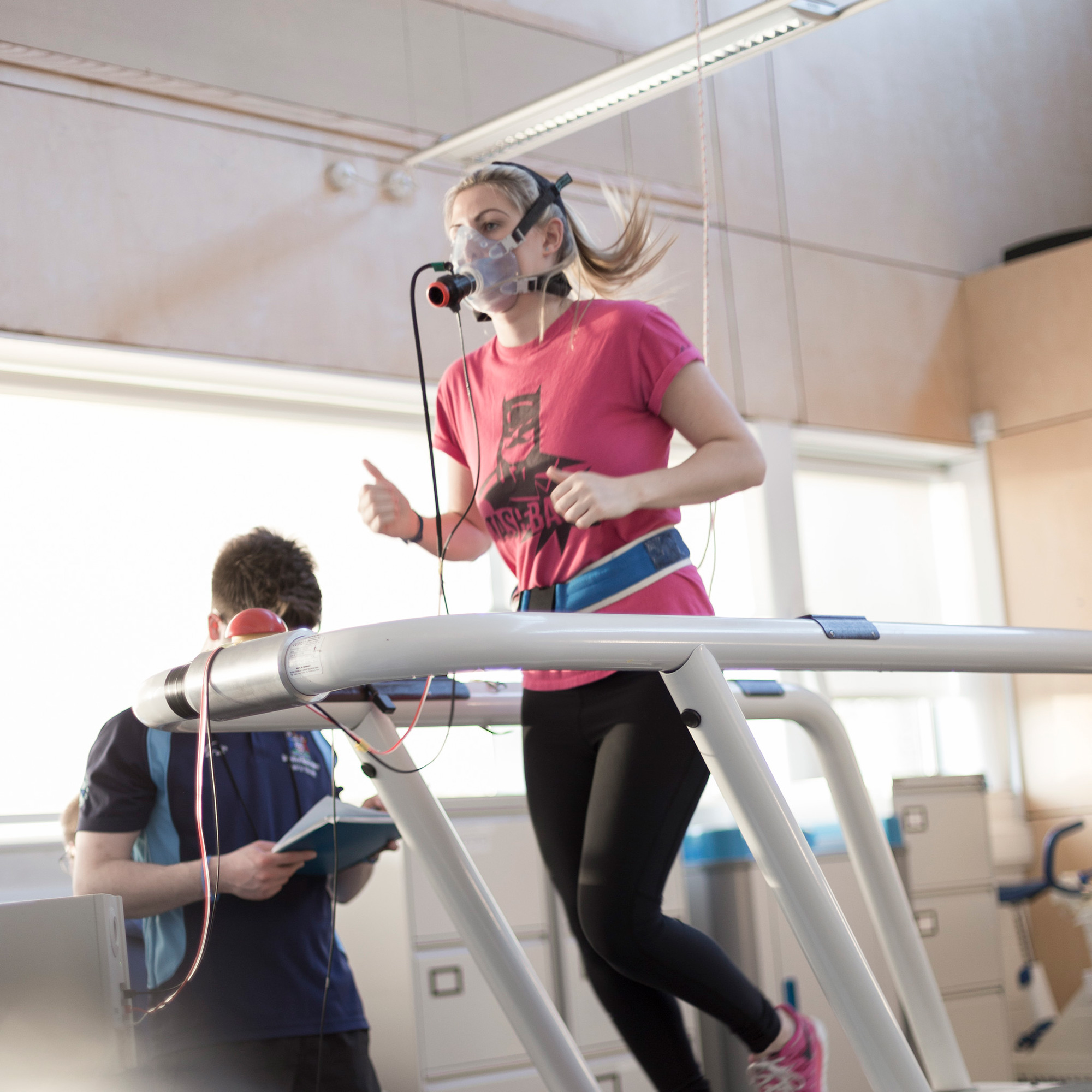 Student on a treadmill connected to respiratory equipment