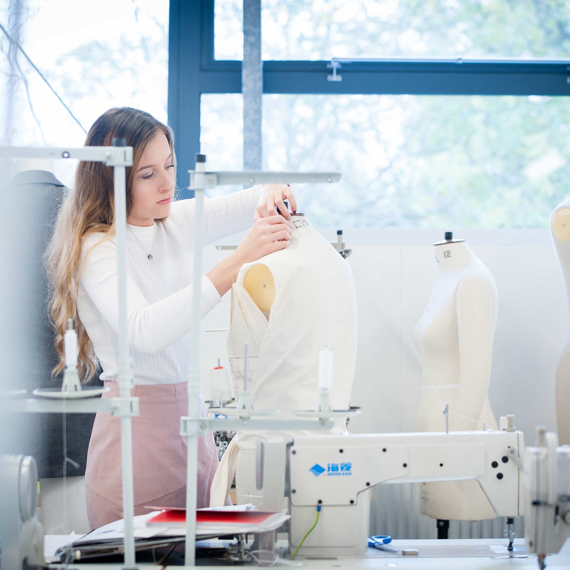 Student pinning fabric on to a mannequin