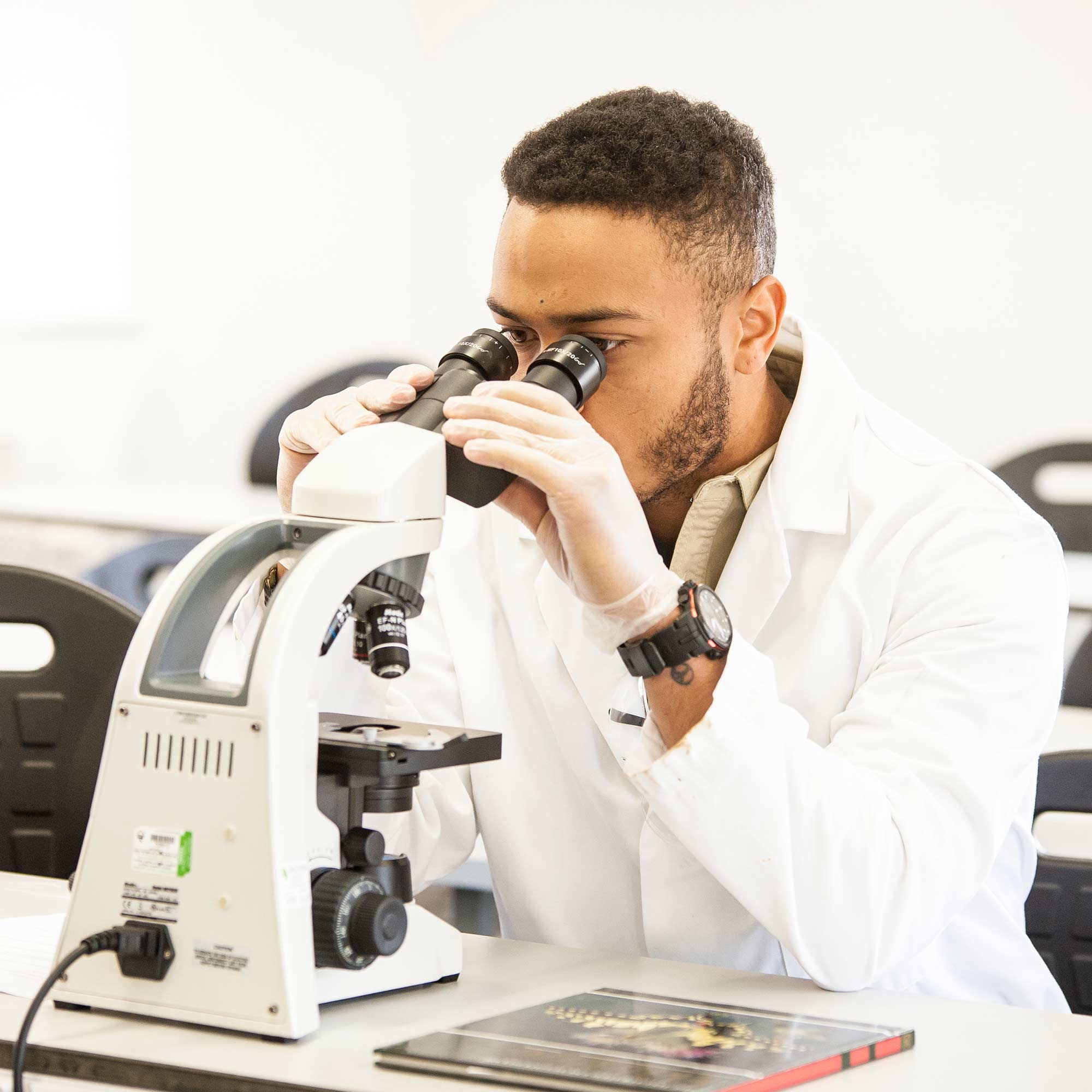 Student using a microscope in lab