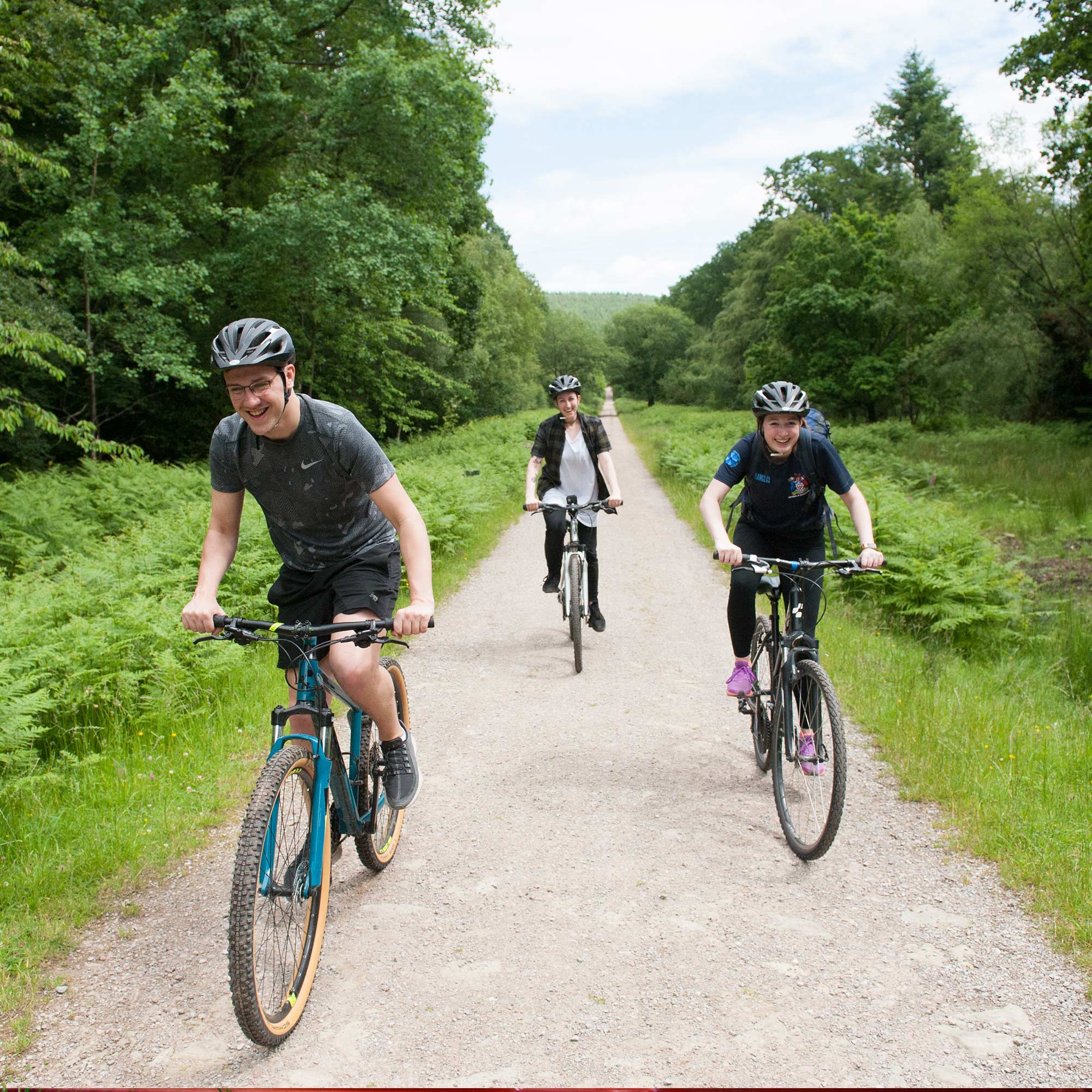 Students cycling on a track in the forest of dean