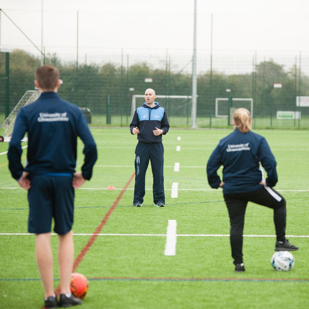 Sports coach speaking to students