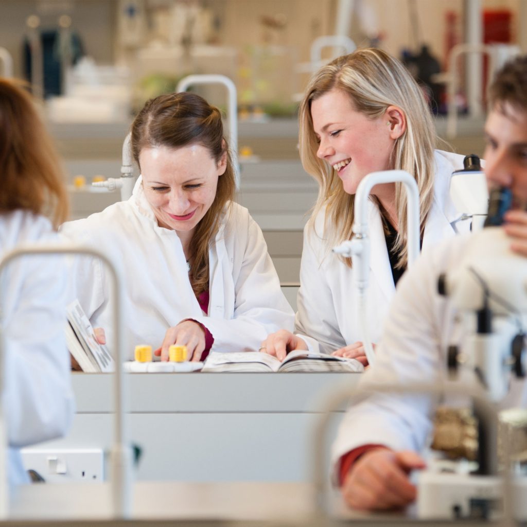 Two students in lab smiling