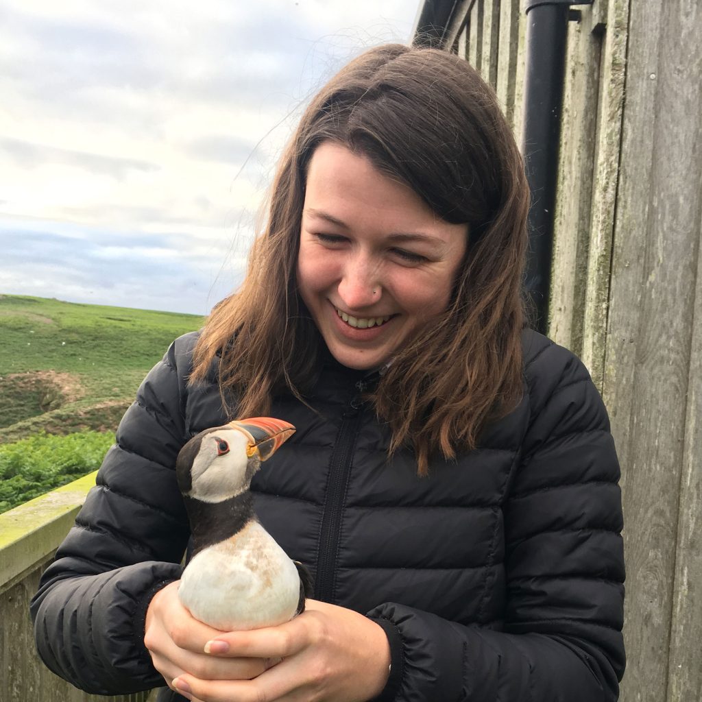 Student smiling whilst holding animal