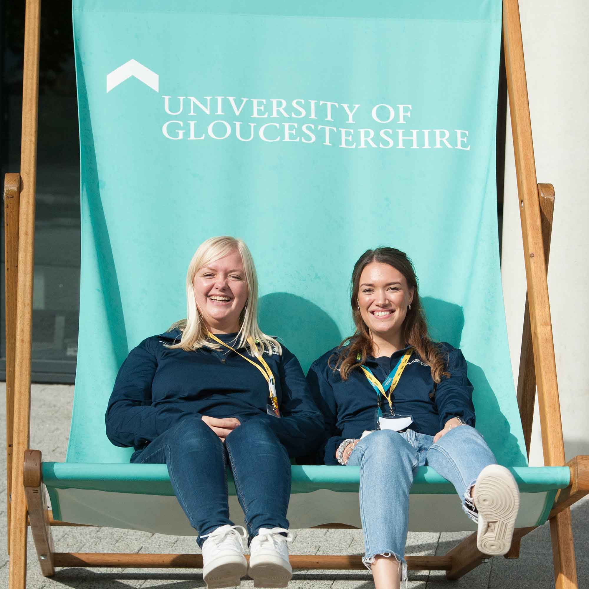 Student ambassadors sat on giant deckchair smiling