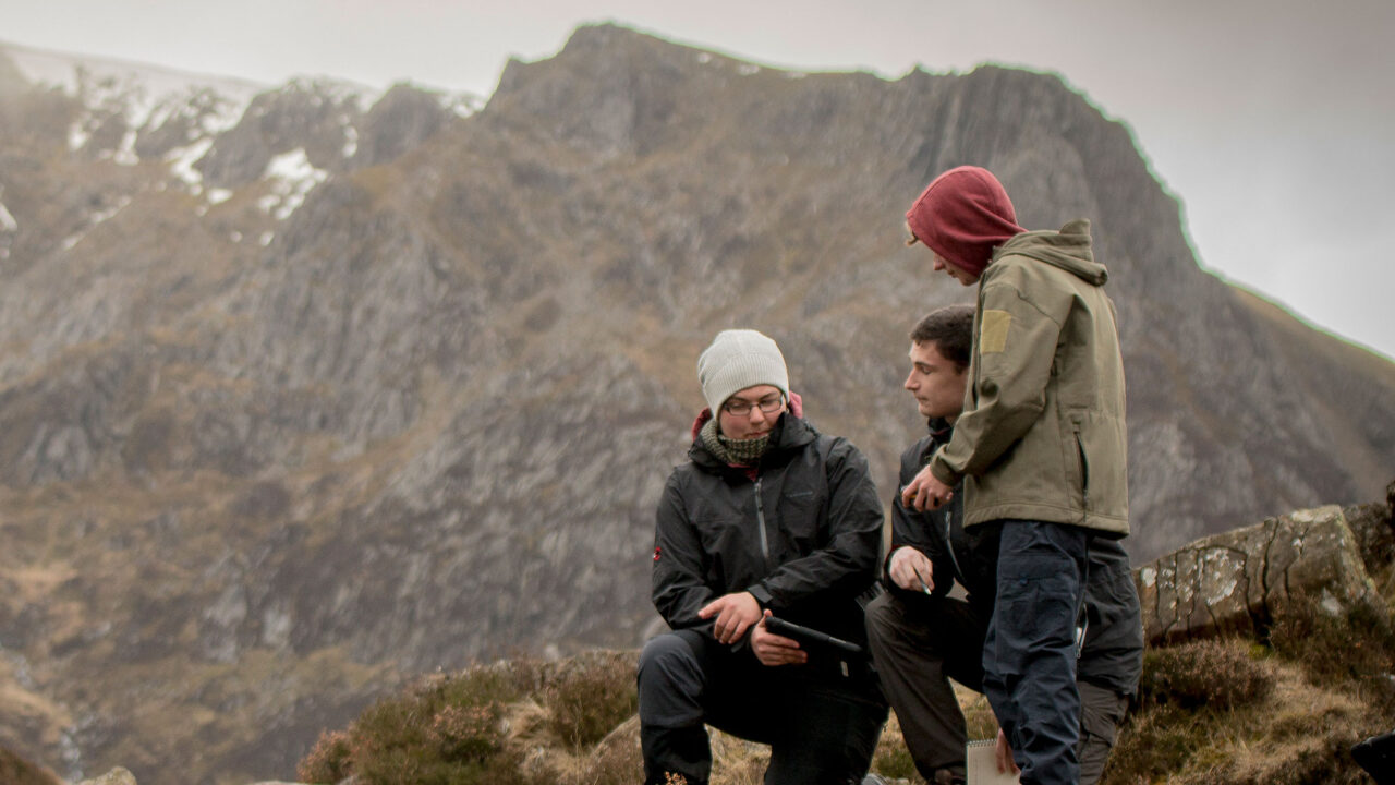 Three students on a mountain having a conversation