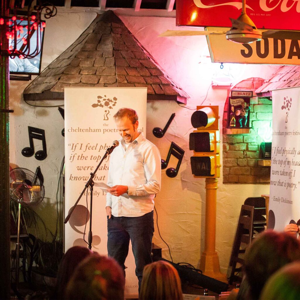 Man reading poetry at Cheltenham Poetry Literature Festival