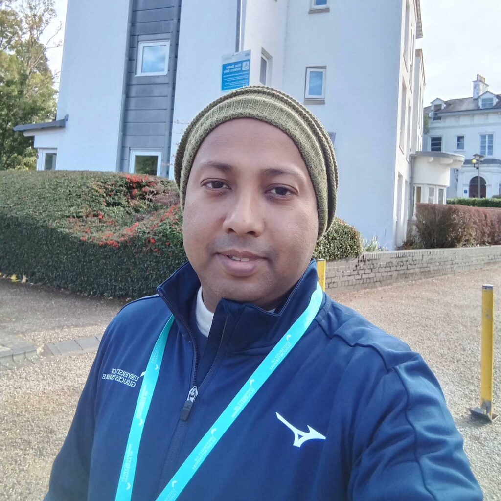 Student Rakib smiling as he stands in front of a university building.