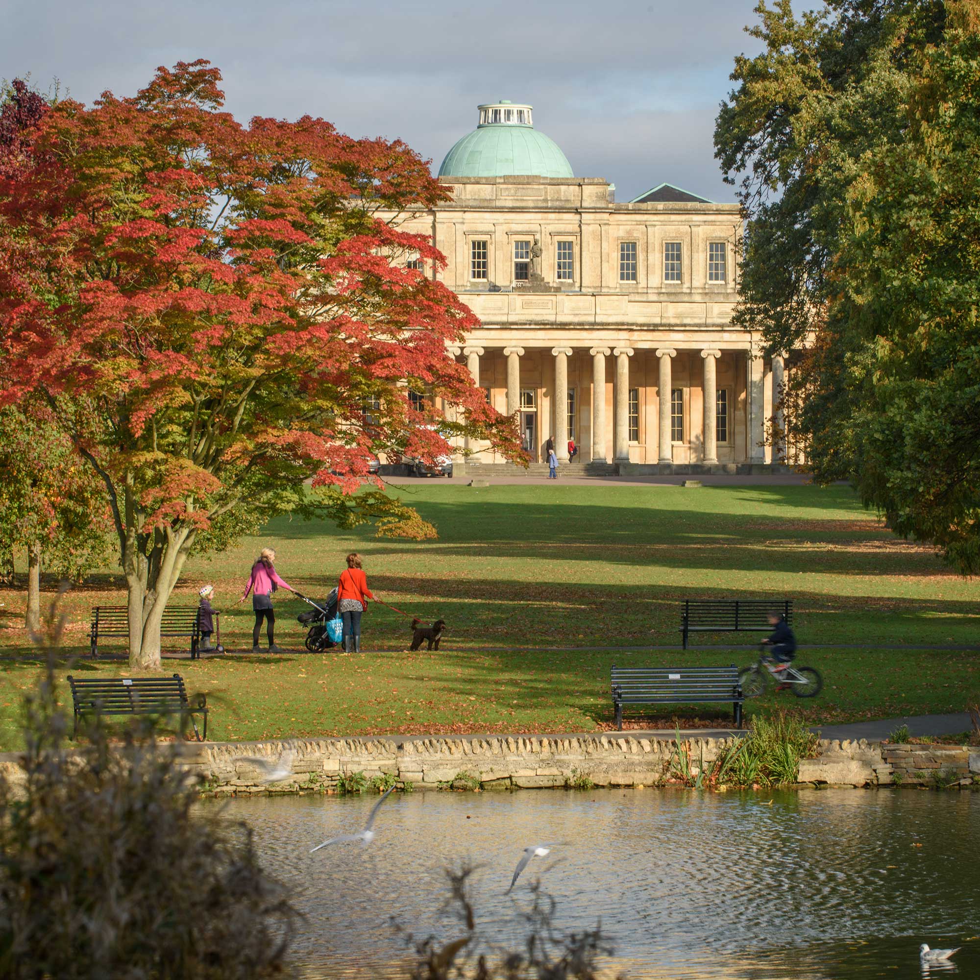 Pittville Pump Room with a lake in the foreground.