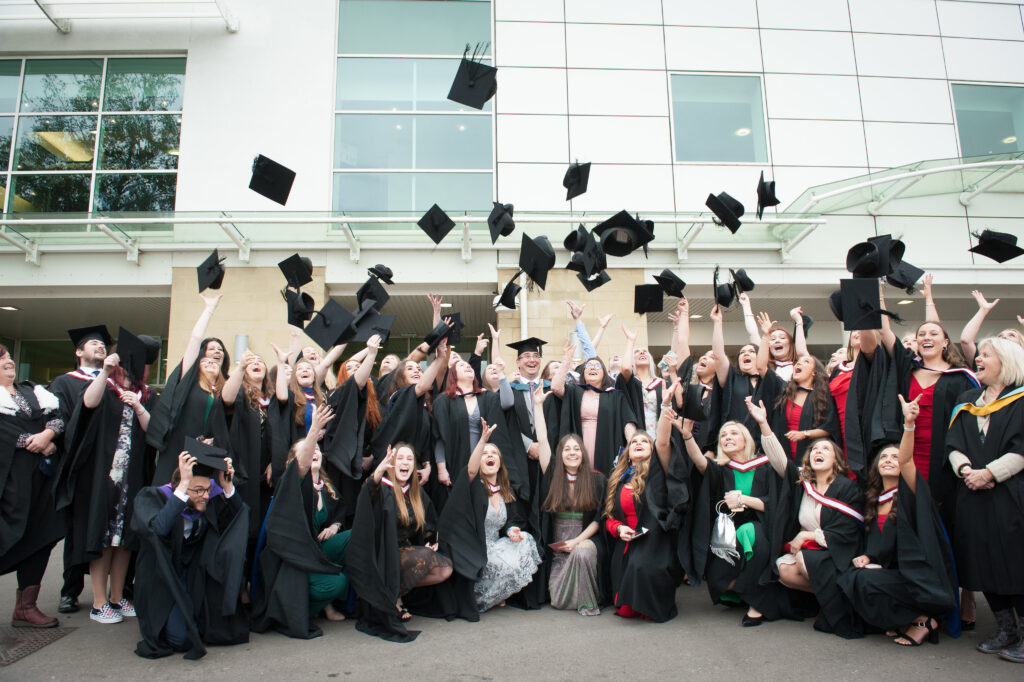 graduates throwing their mortar boards into the air