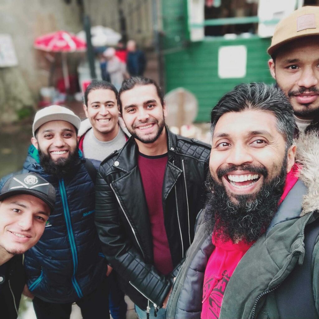 A group of 6 male students smiling while taking a selfie photo.