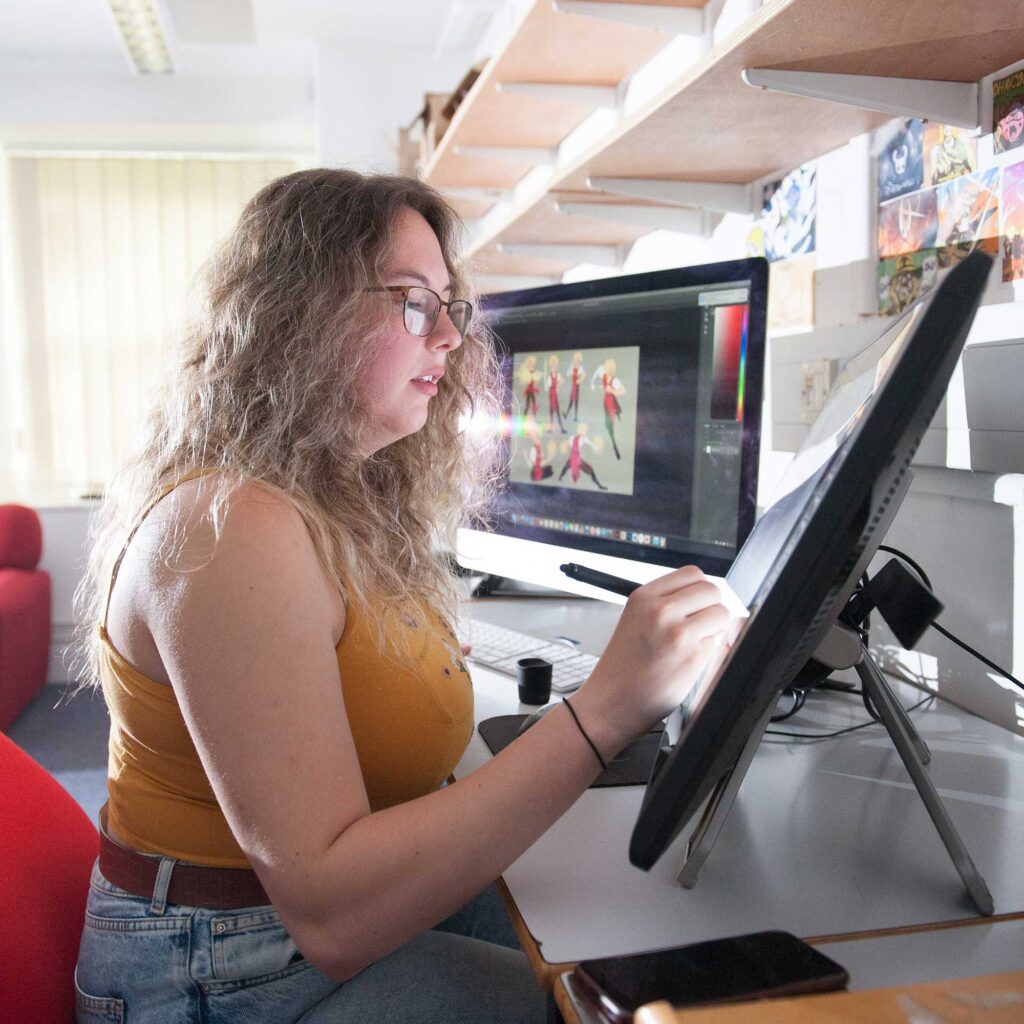 A student working on a design using a touch-screen monitor,