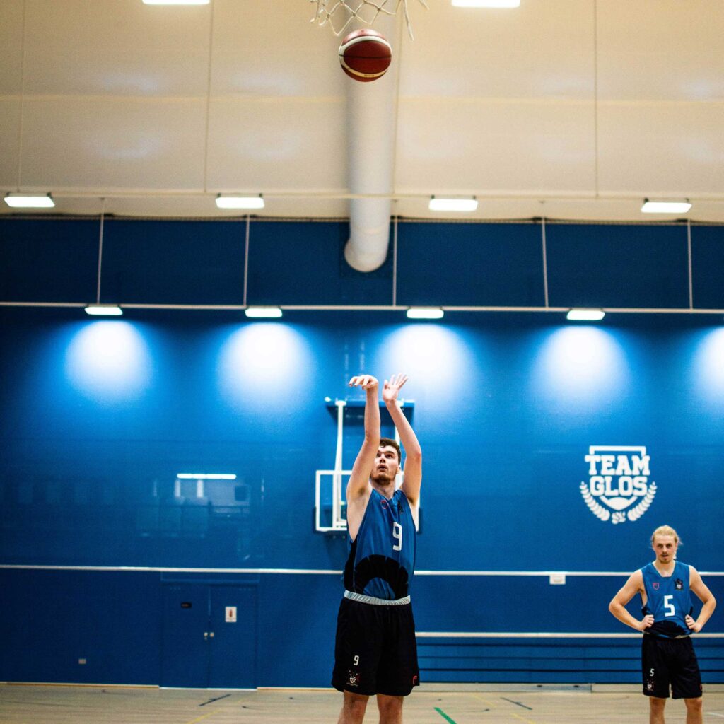 A basketball player aims the ball at the hoop.
