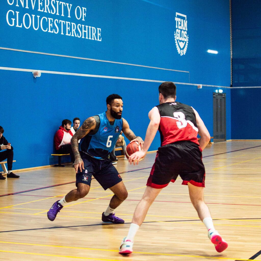 Basketball players playing on an indoor court.