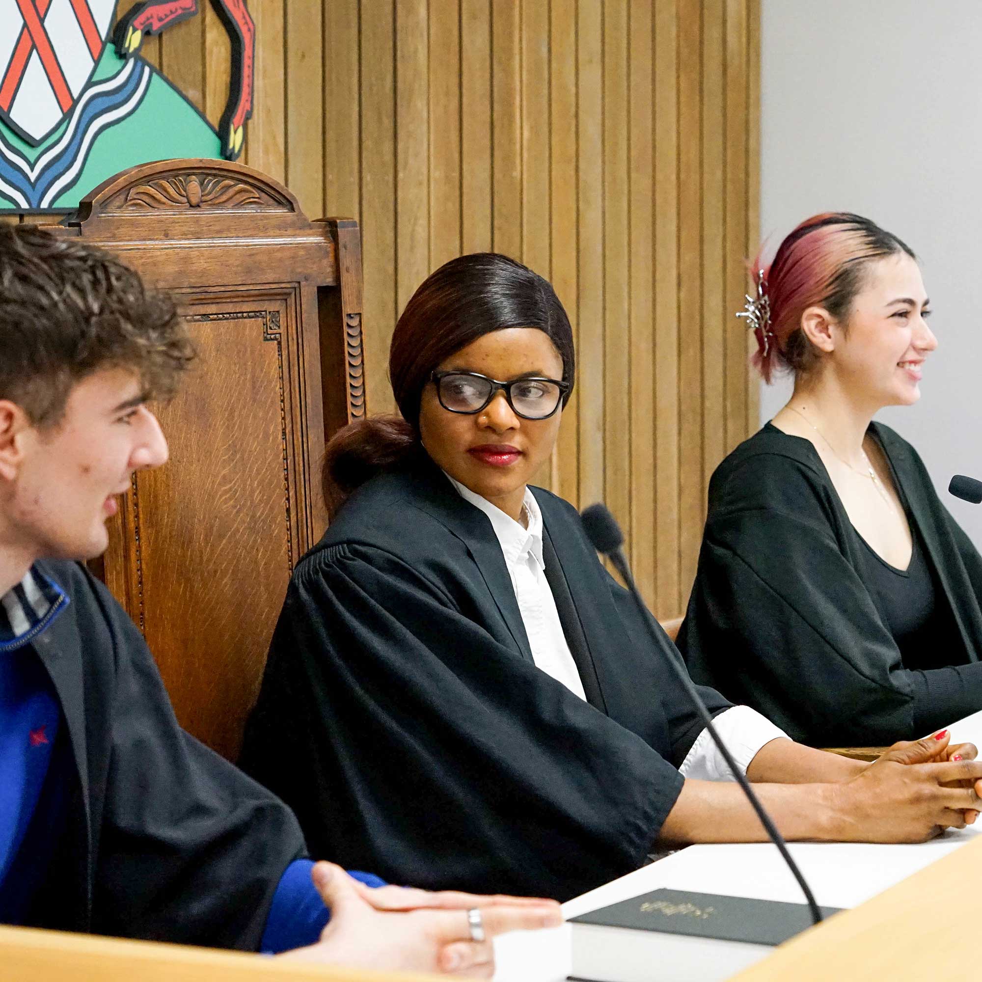 Student wearing robes sitting in the Moot Court.