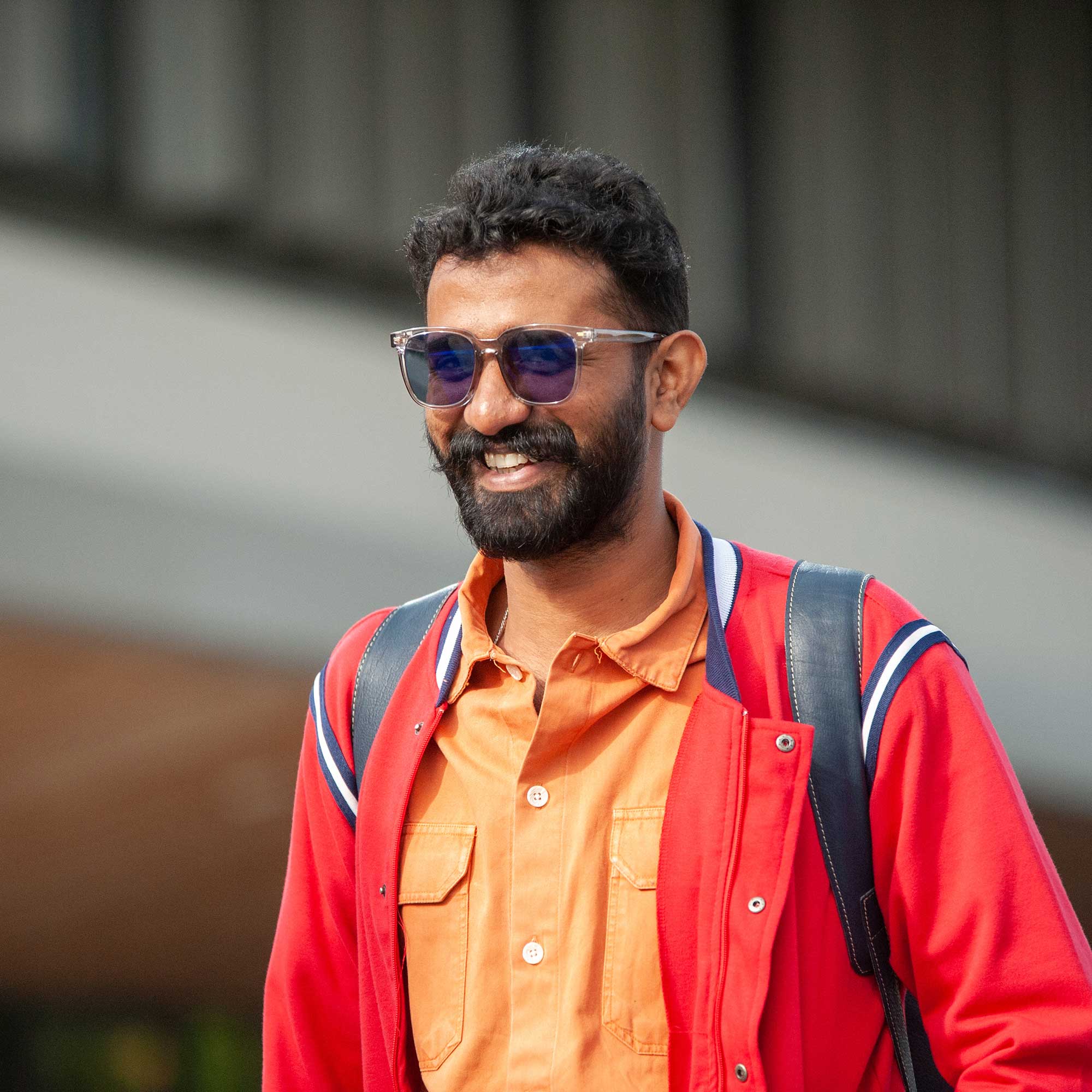 A student stands outside smiling.