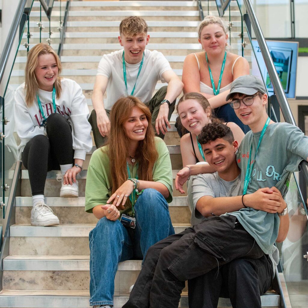 A group of students sit together on some stairs