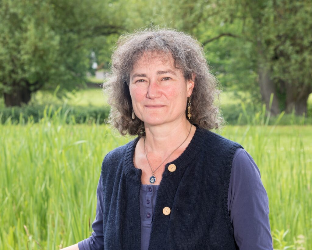 Professor Janet Dwyer with a field and trees in the background