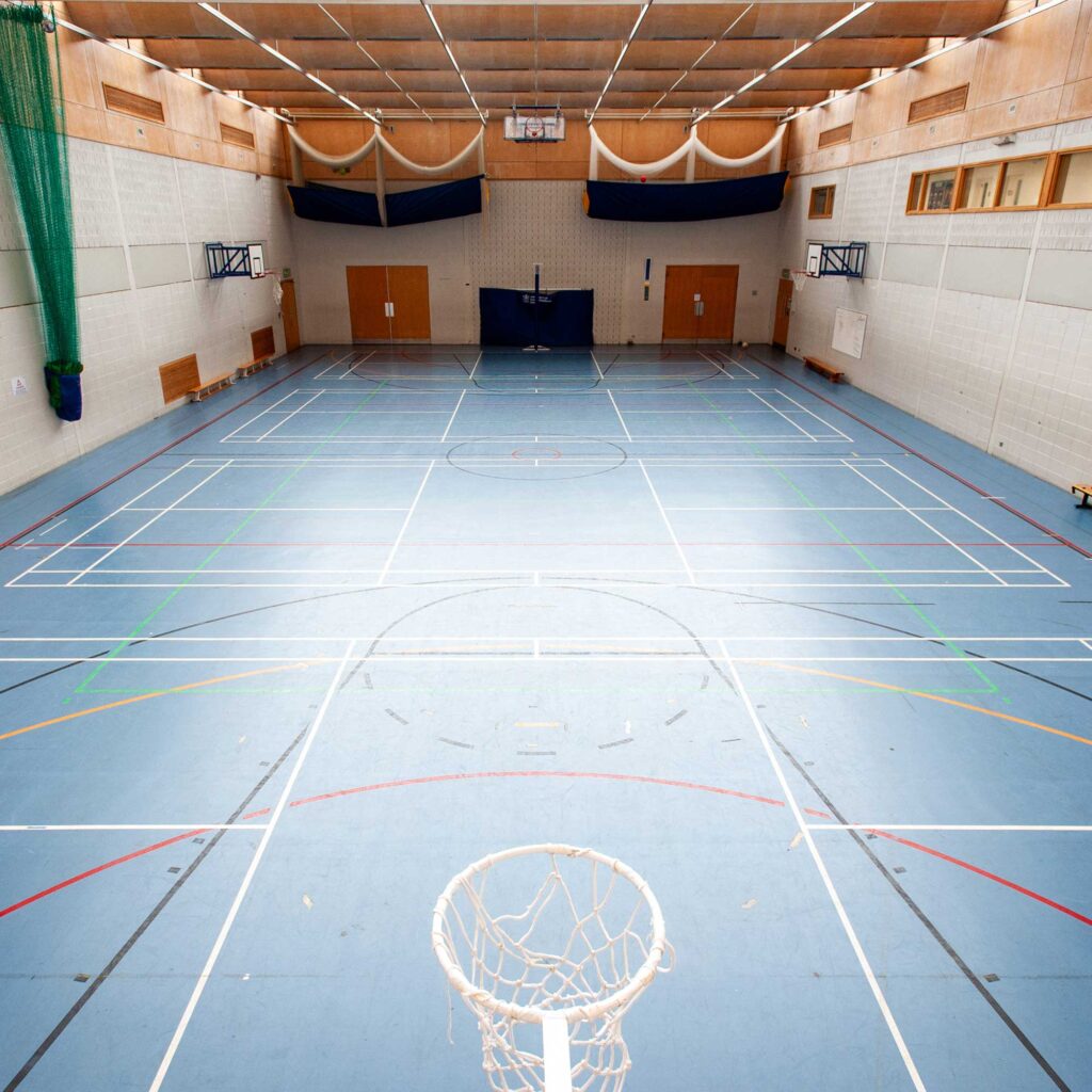 Arial shot of the sports hall at Oxstalls campus, showing markings on court for various sports and netball hoops set up.