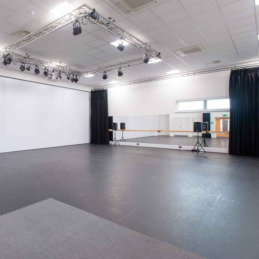 The performing arts studio at Oxstalls campus, with mirrors, a barre and speakers set up.