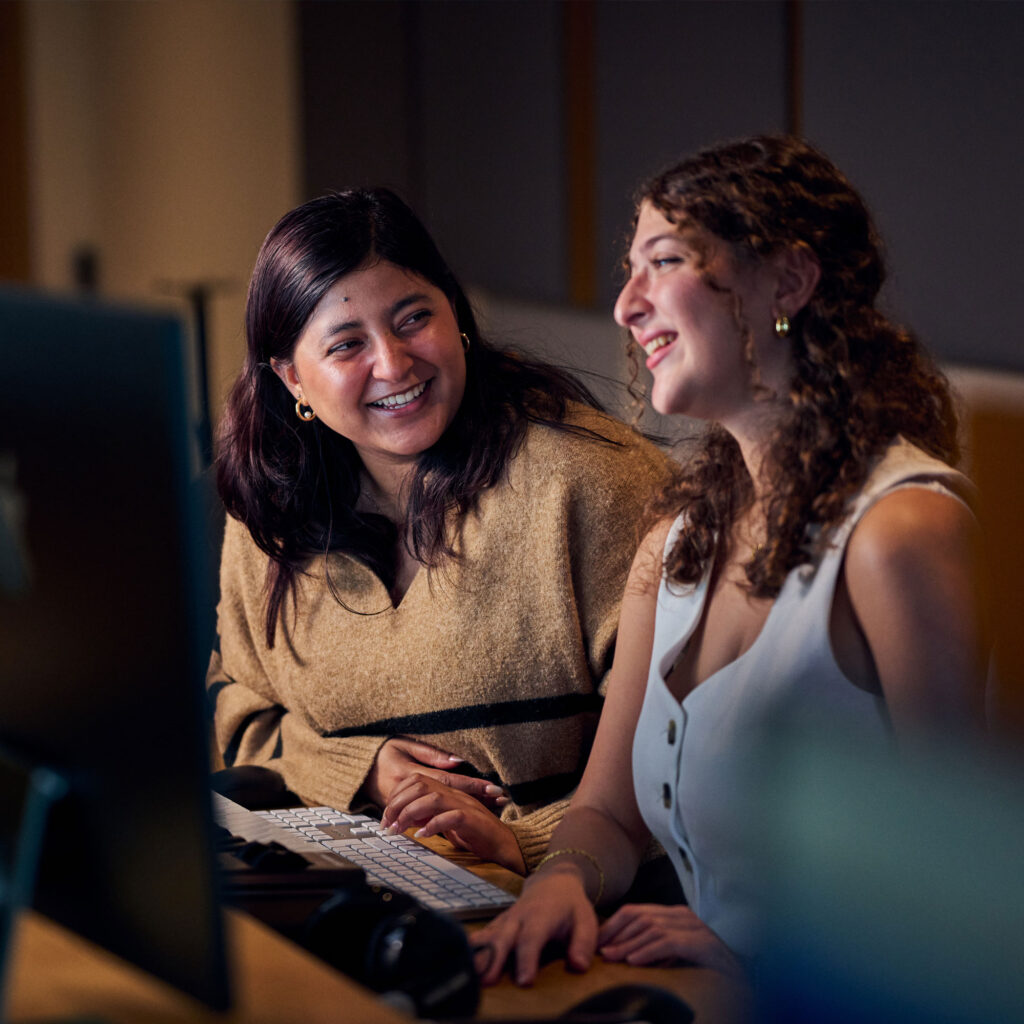 Students working at computers smiling