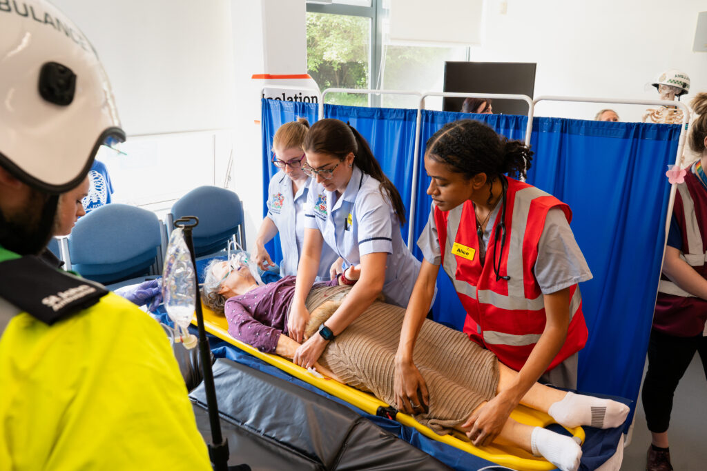 Nursing students examining a patient while they are lay down