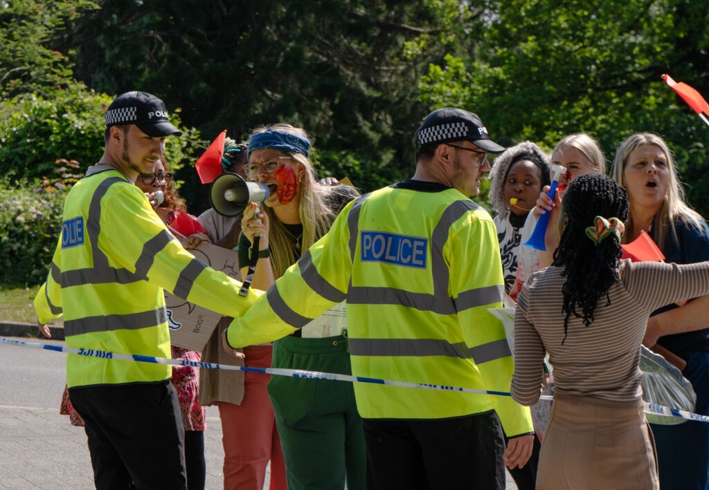 two police officers acting as a barrier to a group of protesters