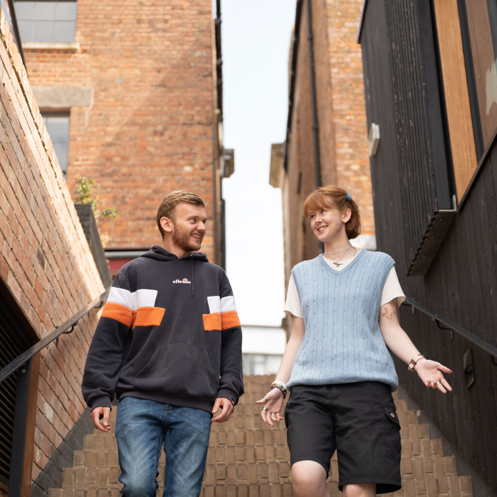 Two students walking down steps in Gloucester City Centre
