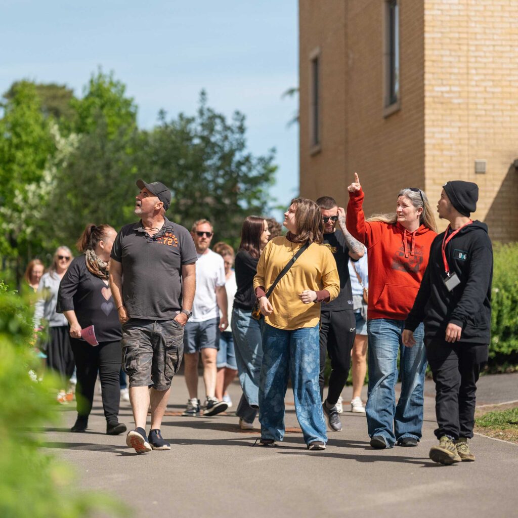 A group of visitors on a campus tour led by a student ambassador.