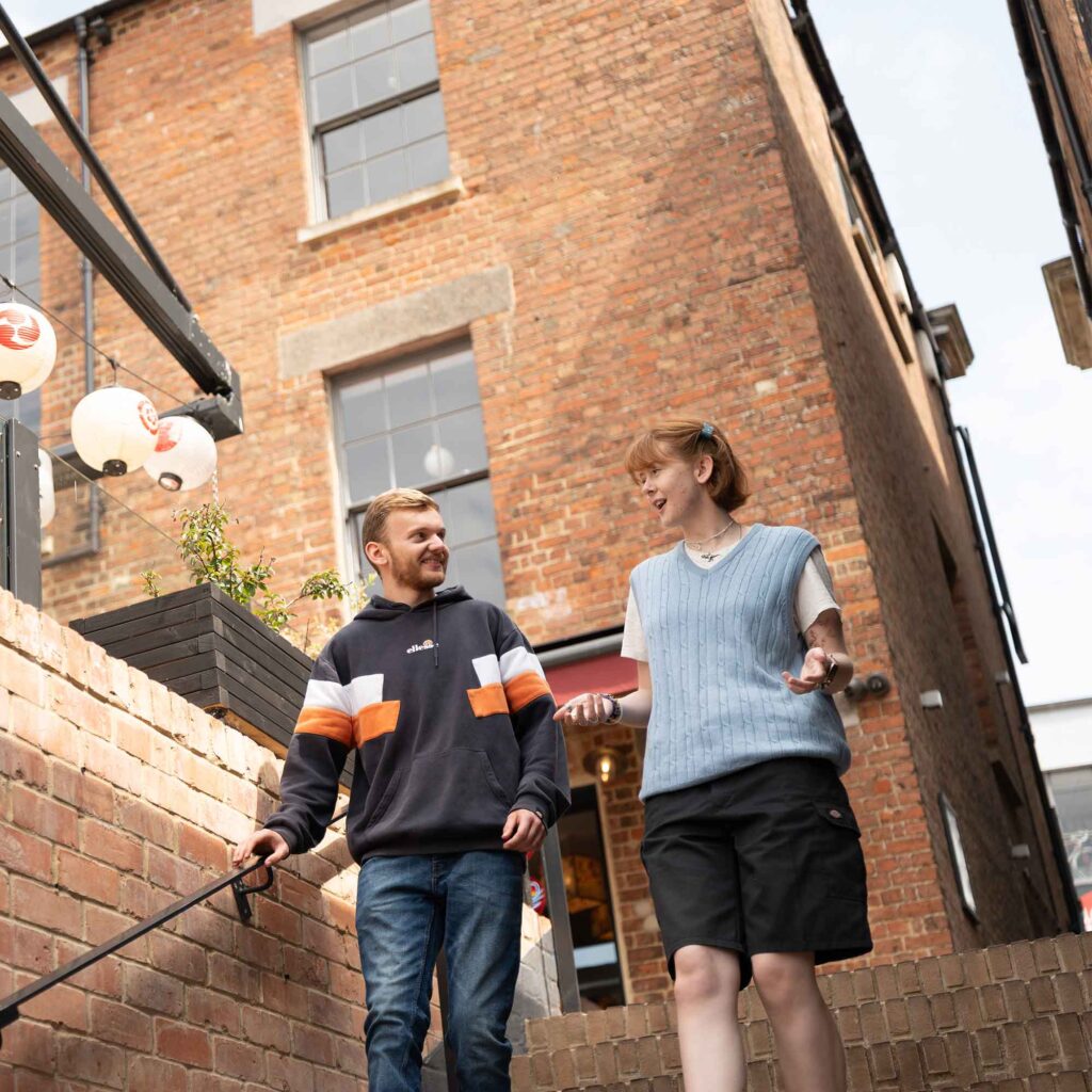 Two students walking down some steps in Gloucester.