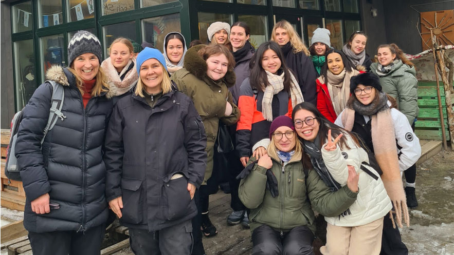 A group of students and teachers pose for a group photo during their trip to Sweden